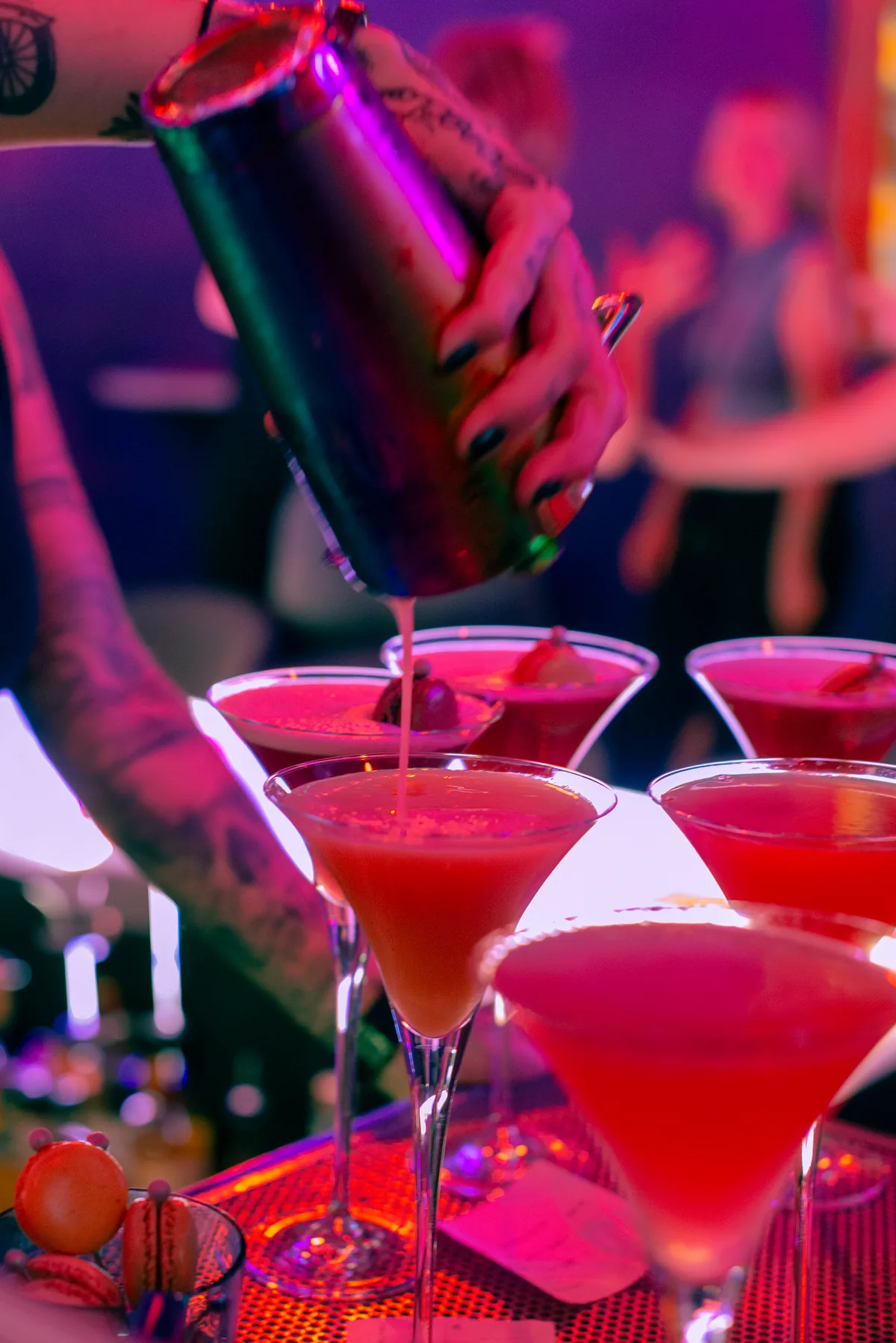 Fresh pink cocktails being poured at Lola’s neon-lit bar